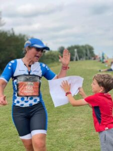 Triathlete running along and giving a high five